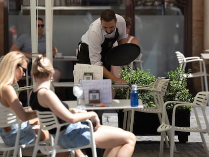 Un camarero trabaja en la terraza de un bar de Sevilla.