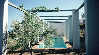 Piscina enmarcada por la pérgola.