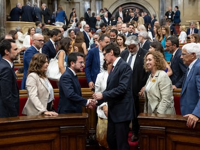 Salvador Illa (en el pasillo) estrecha la mano de Pere Aragonès al finalizar el pleno de investidura en el Parlament, este jueves.