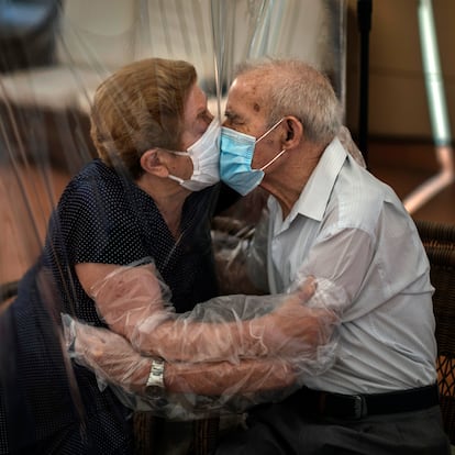 Una pareja se besa a través de un plástico.